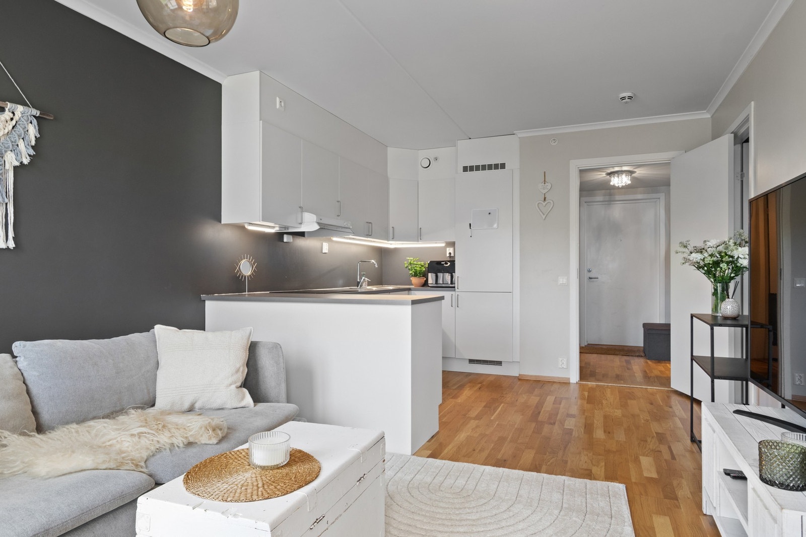 Det er parkett på gulv, malte plater på vegg og malt betongdekke i tak. Galleribilde