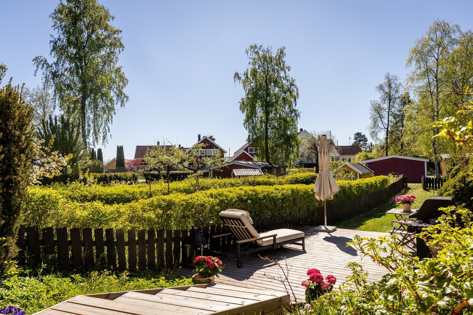 Terrassen ligger på et høyere nivå, slik at man får god oversikt over uteområdet. I bakgrunn ser du sameiets tennisbane og volleyballnett. Galleribilde
