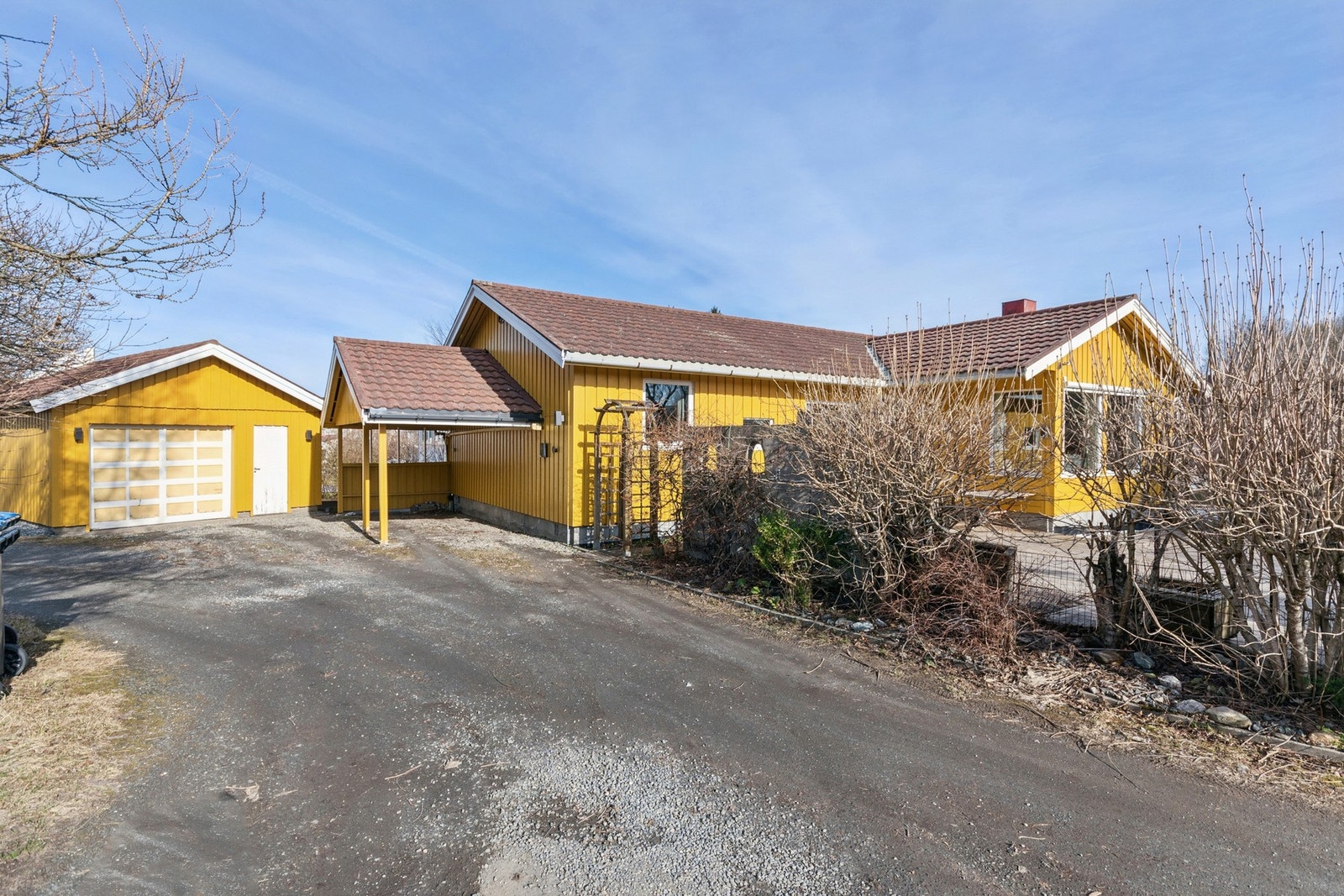 Parkering i garasje, carport og i gruset innkjørsel. Det er etablert elbil-lader i carporten. Galleribilde