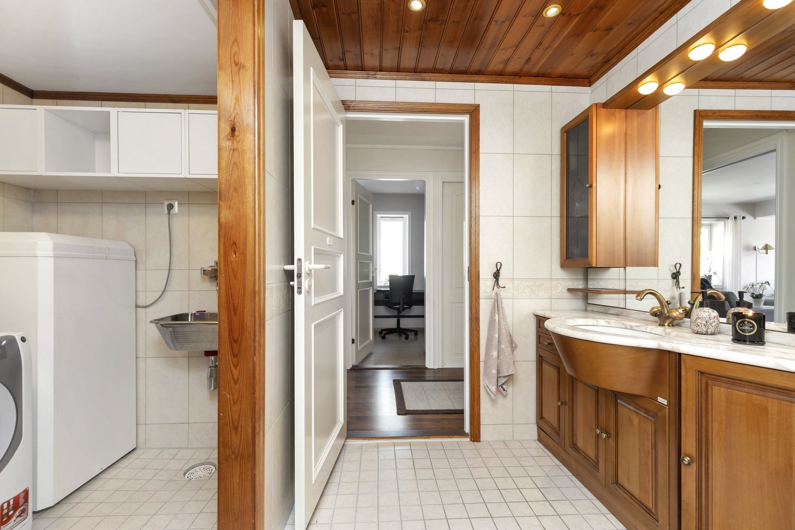 Badet er kombinert vaskerom med opplegg for vaskemaskin og en praktisk utslagsvask. Galleribilde