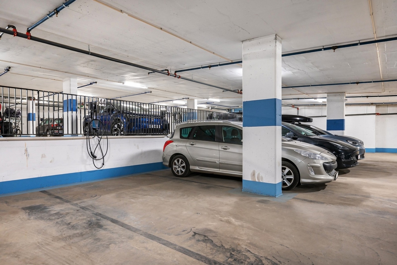 Garasjeplass med elbillader. Det er også flere gjesteparkeringsplasser. Galleribilde