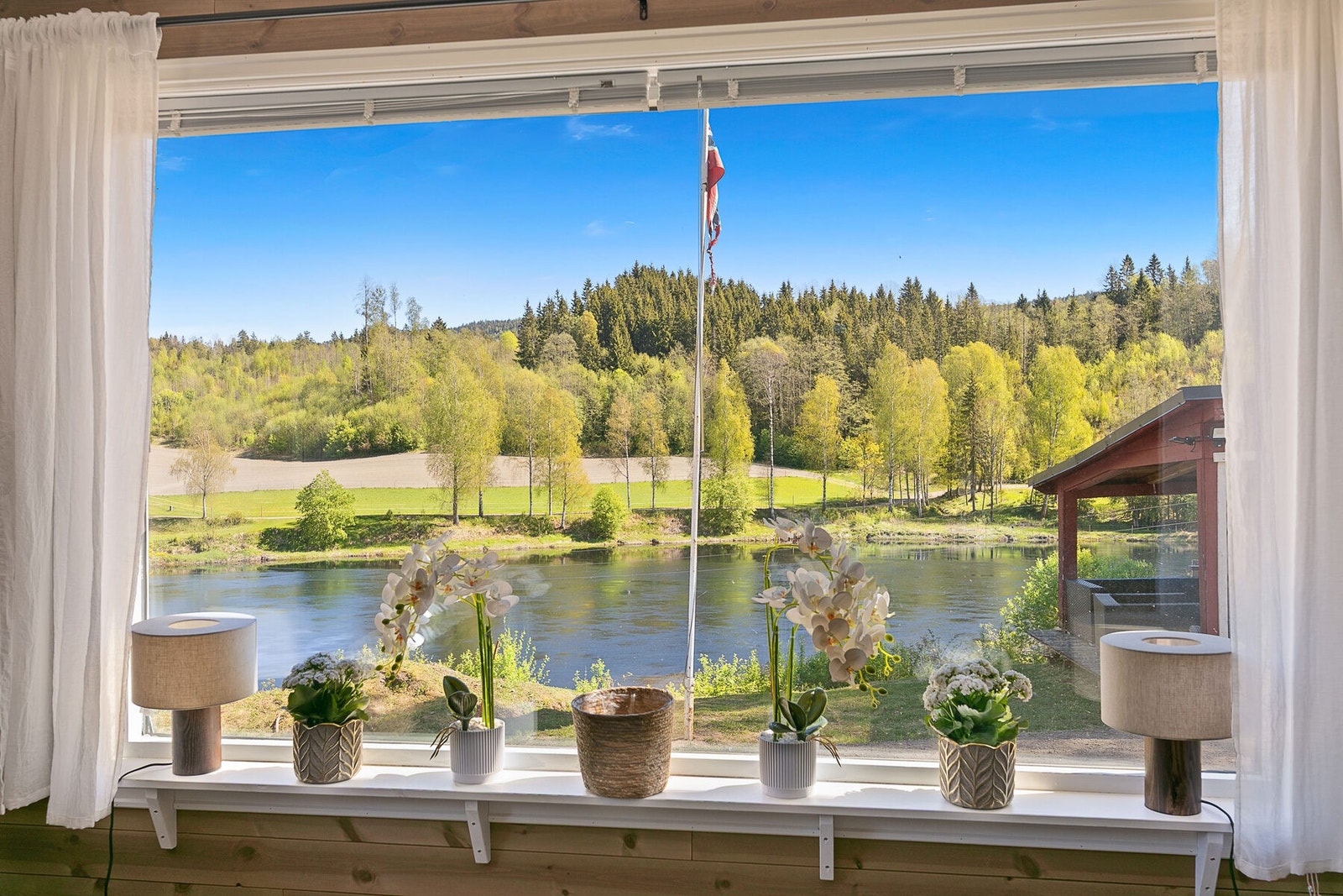 Utsikten til Lågen følger deg inn i stua. Legg også merke til flaggstanga. Galleribilde