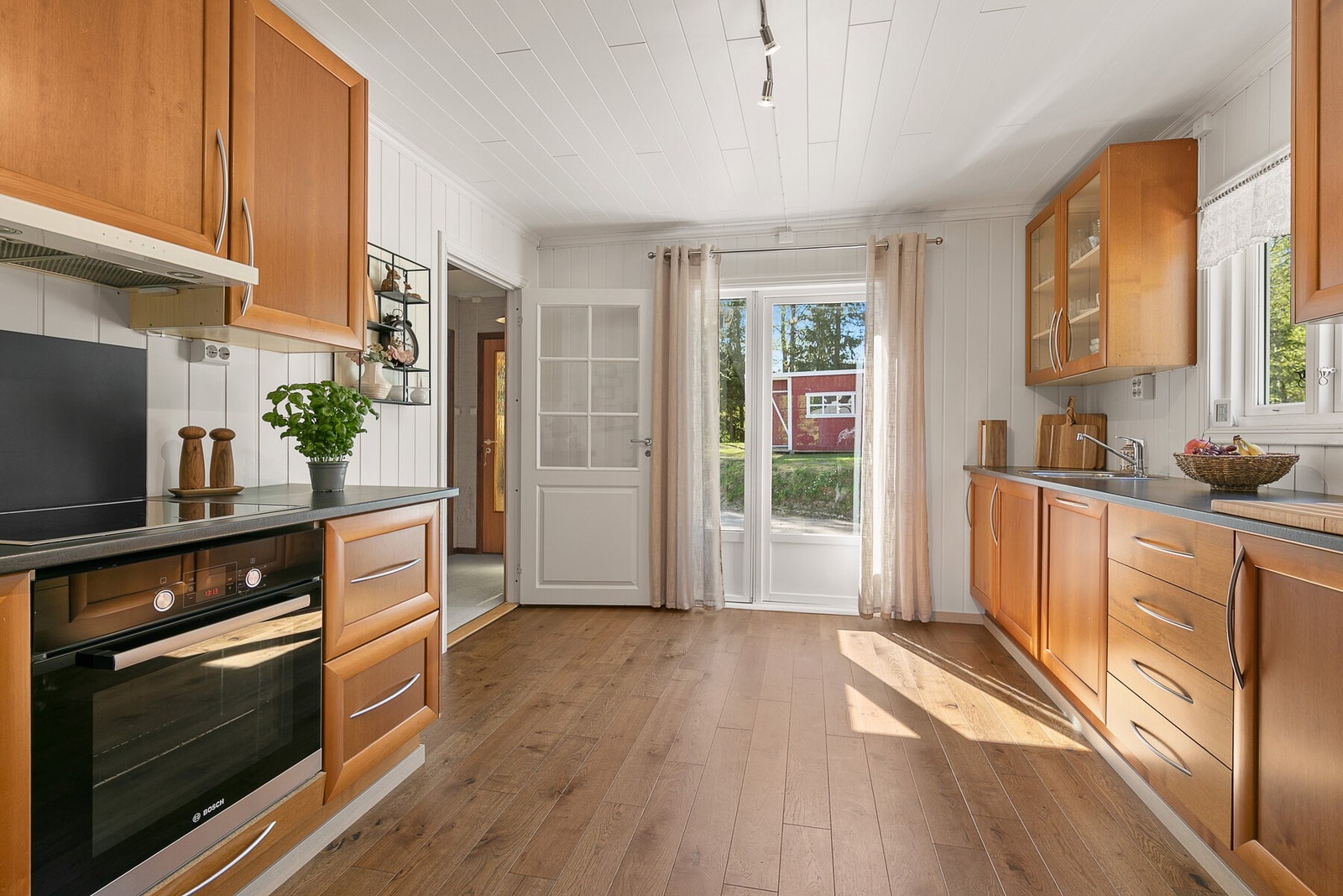 Kjøkkenet har rikelig med oppbevaringsplass, samt utgang til terrasse. Galleribilde