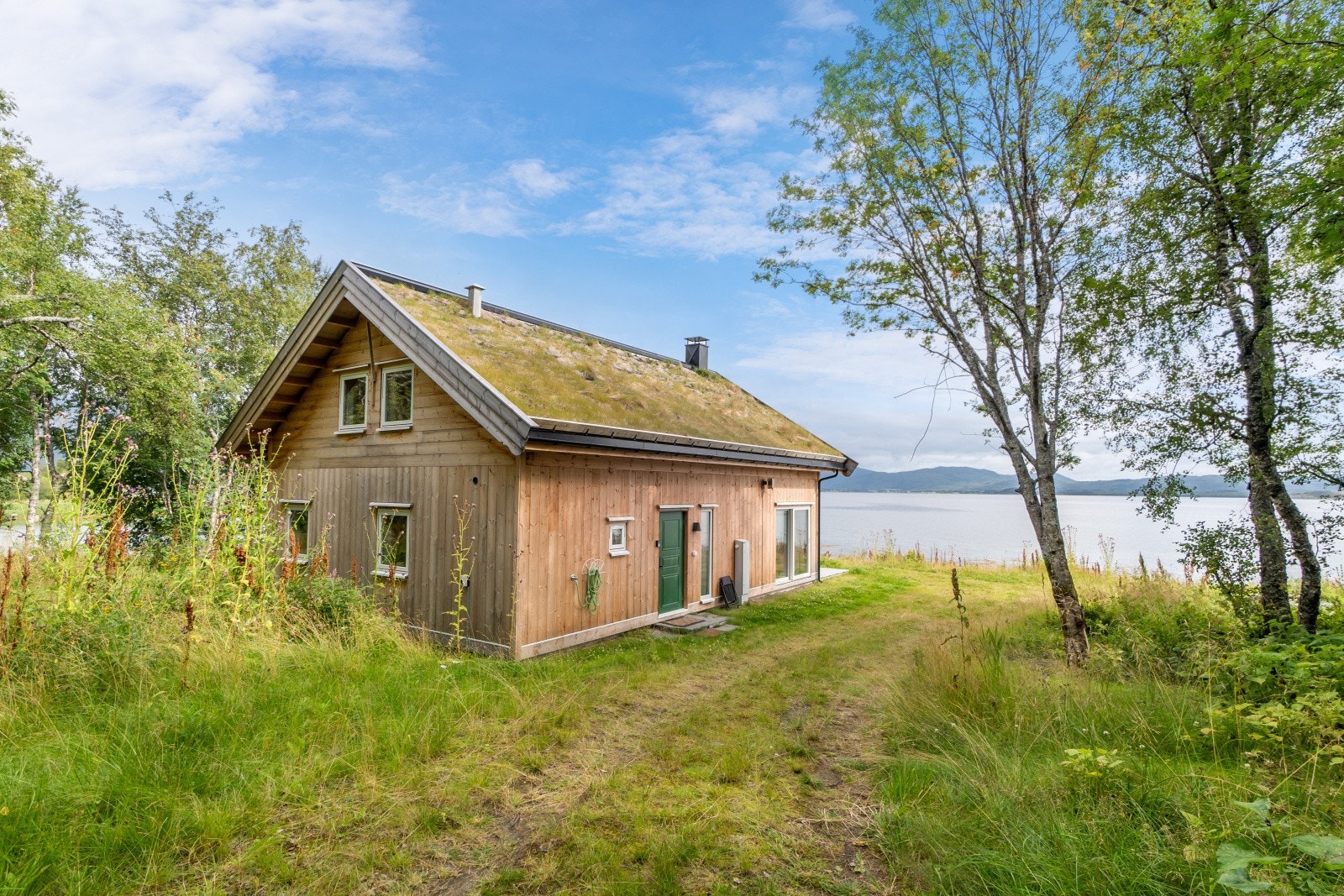Hytta er omkranset av bjørkeskog og naturterreng, som gir en privat og tilbaketrukket ramme. Galleribilde