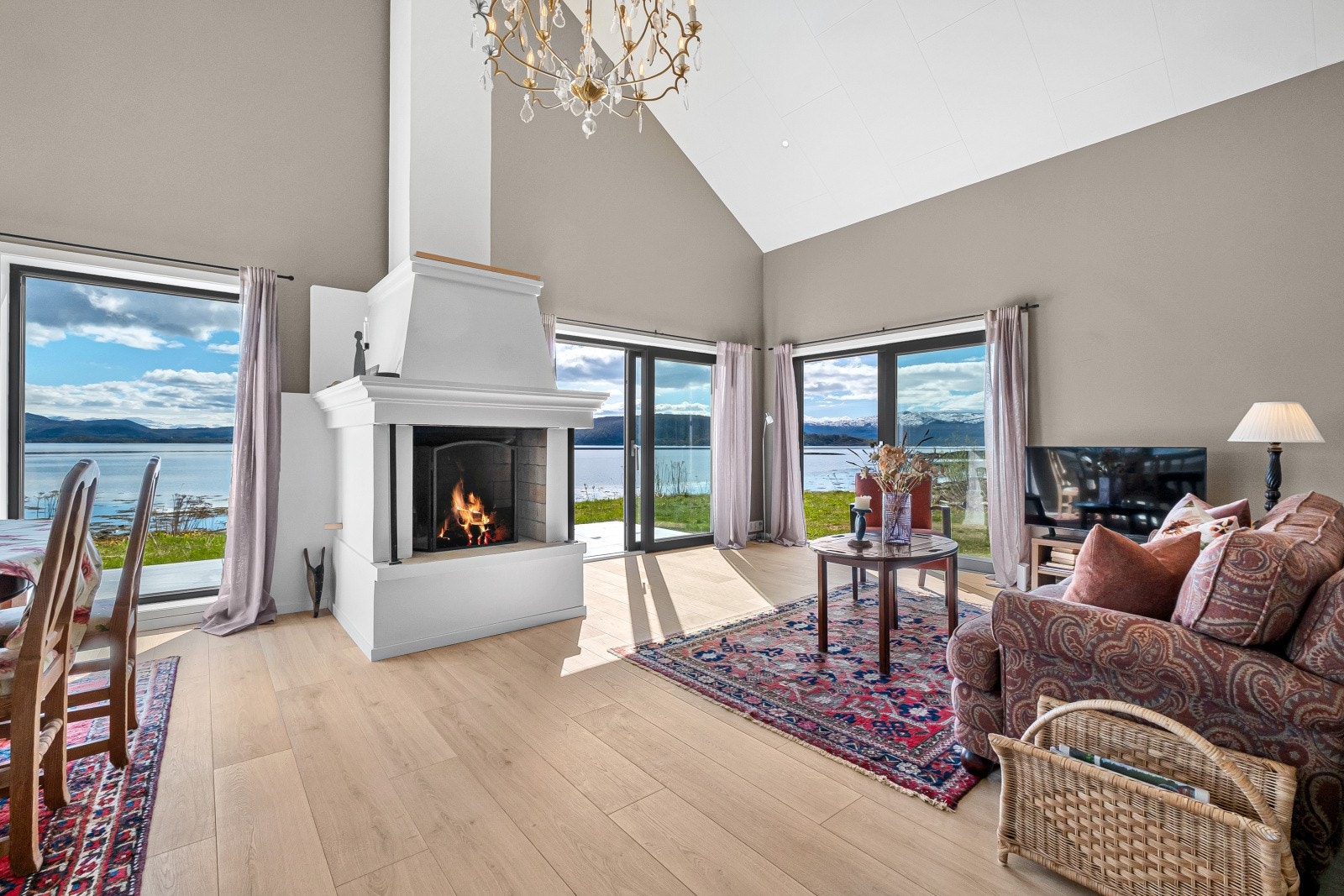 Store vindusflater og skyvedør åpner stuen mot terrassen og fjorden. Galleribilde