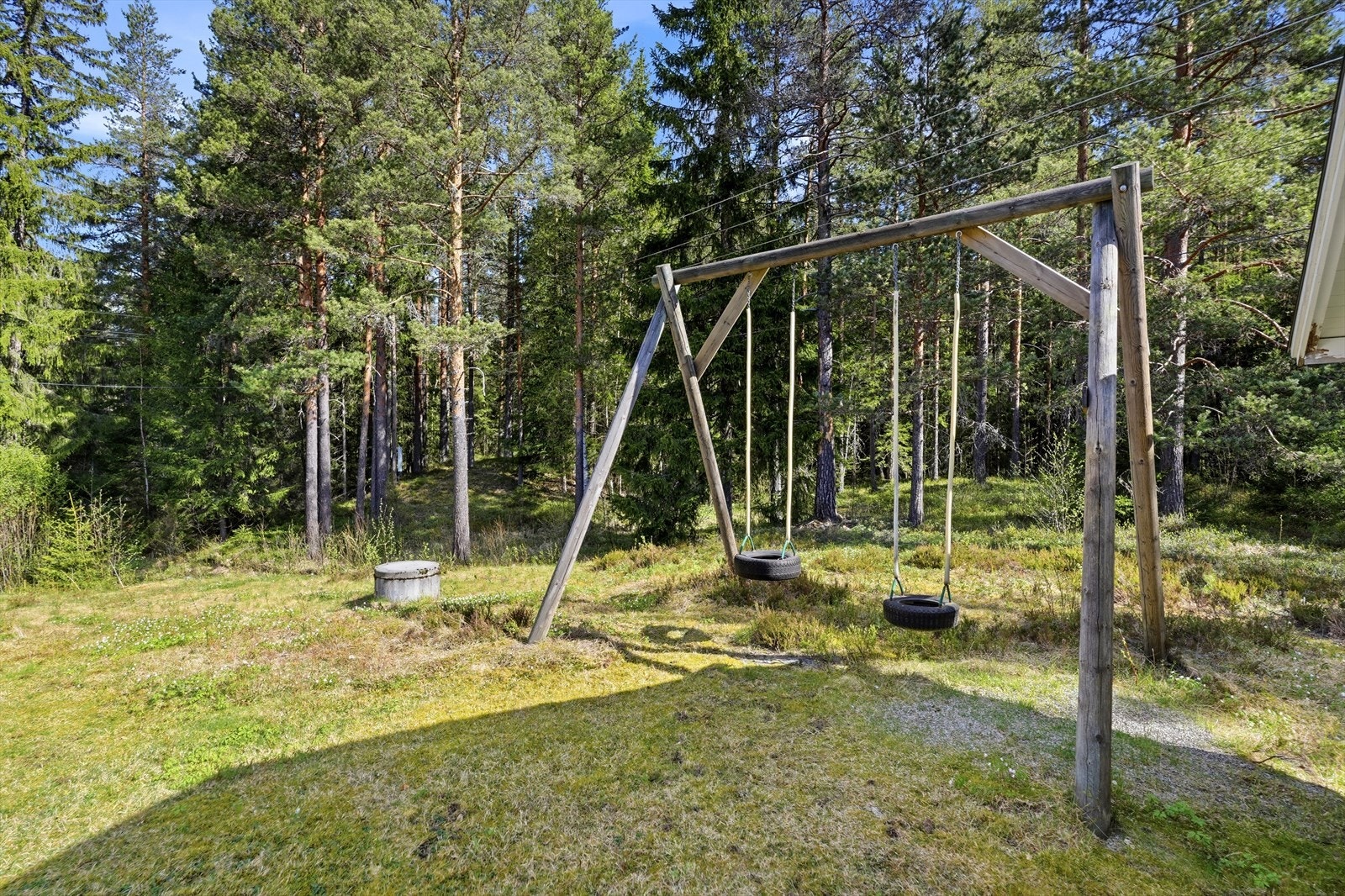 Tomten er opparbeidet med gressplen og beplantning, og grenser mot skogsområder. Galleribilde