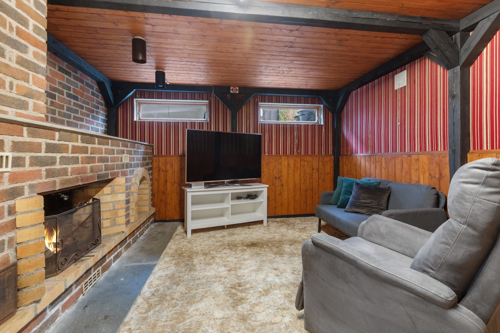 Innredet kjellerstue med en åpen peis. Galleribilde