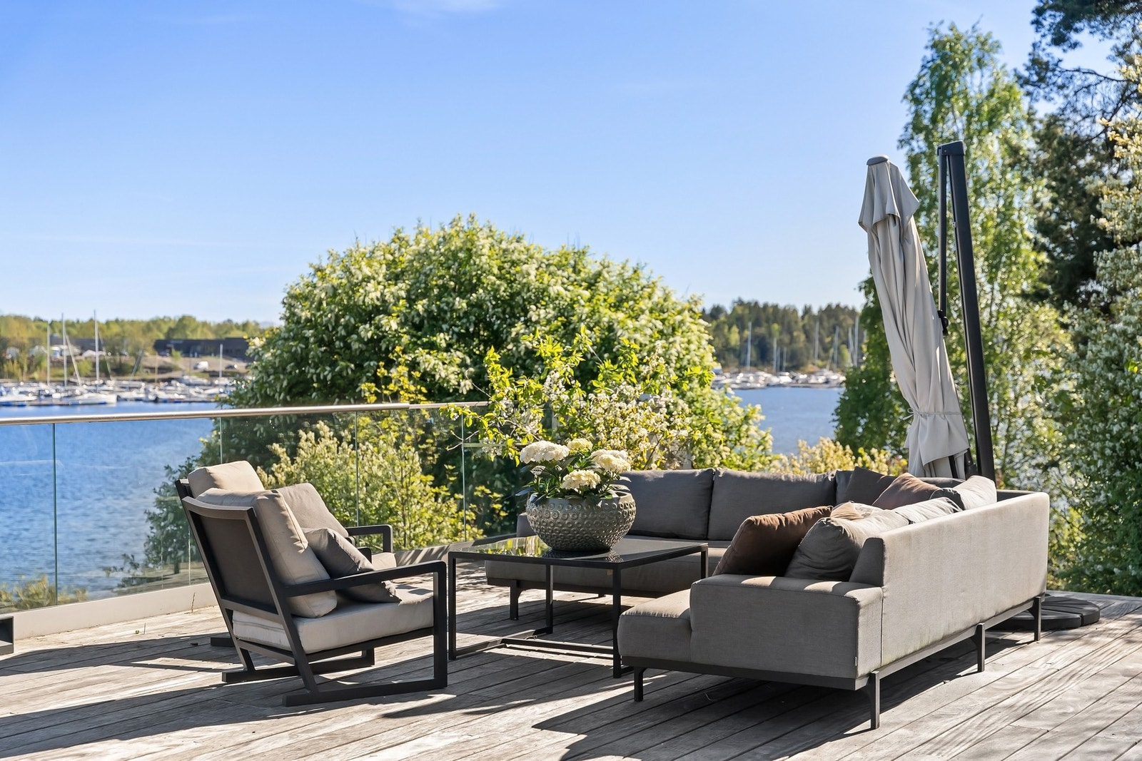Stor terrasse oppført i 2022 med brasiliansk teak og glassrekkverk. Galleribilde