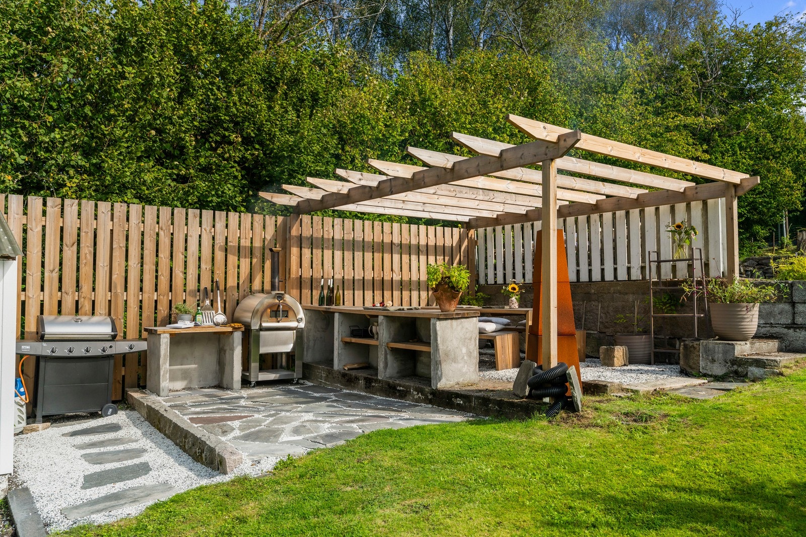 Et solid, plassbygd utekjøkken med pergola. Galleribilde