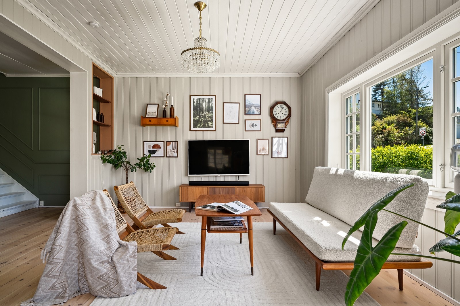 Vinduene rammer inn den grønne hagen og slipper rikelig med lys inn i stuen. Galleribilde