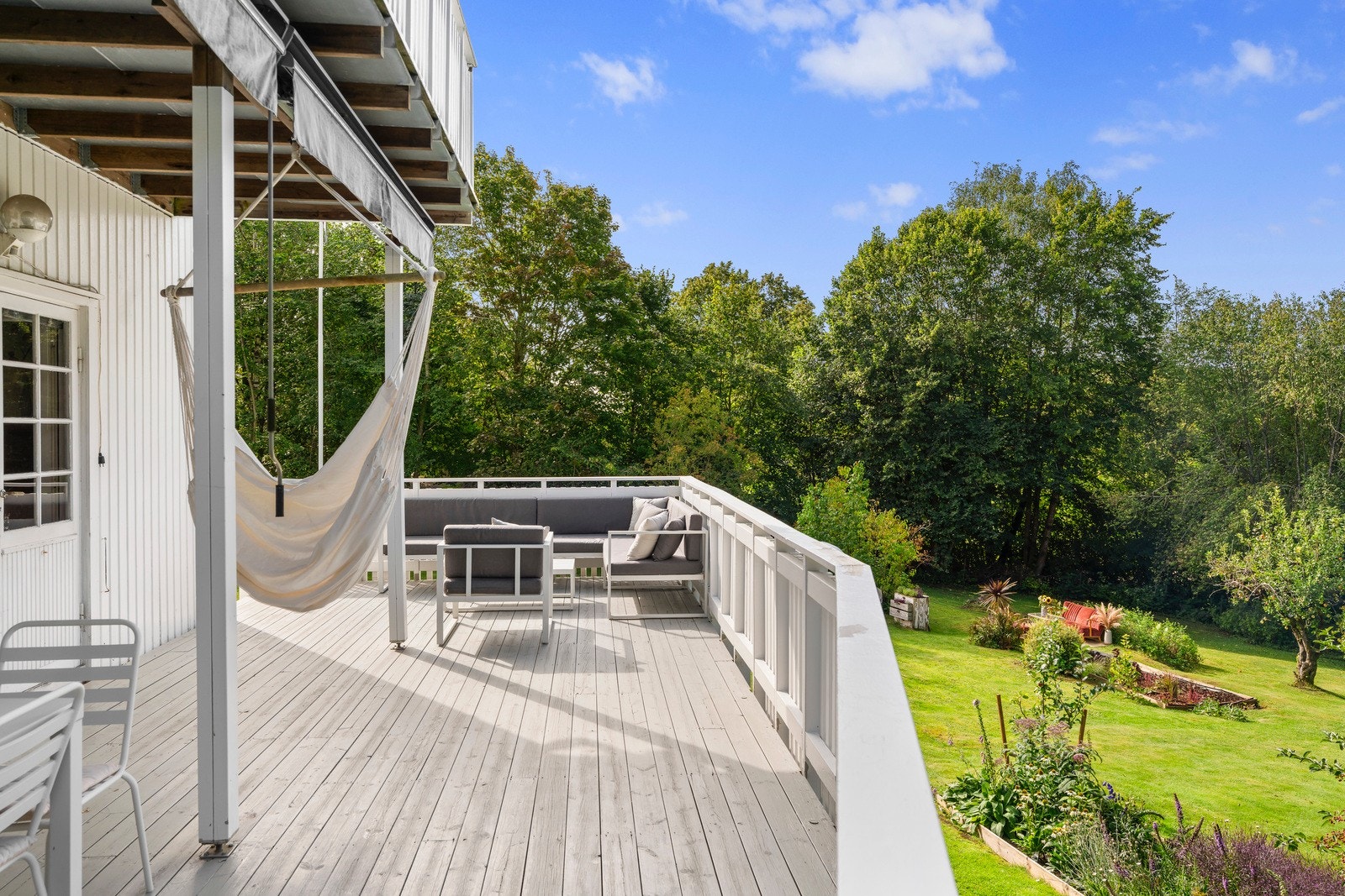 Terrassen har gulv med terrassebord og gir en flott utsikt over hagen. Galleribilde