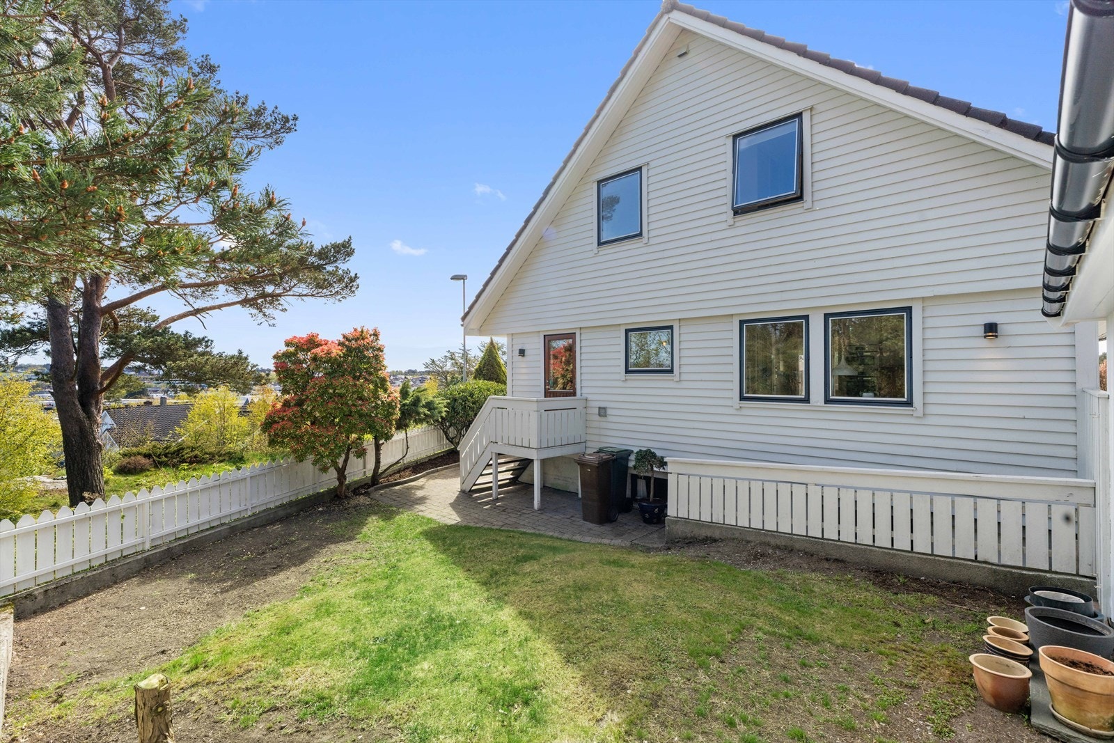 Baksiden av huset med biinngang og uteplass. Galleribilde