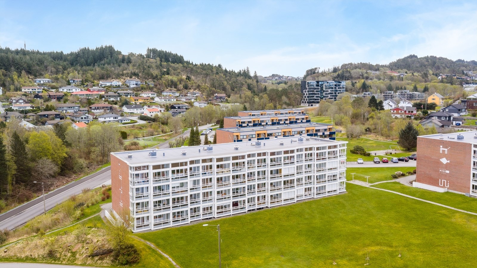 Pent opparbeidet fellestomt med asfalterte parkeringsplasser og rikelig med grøntareal/gressplener. Galleribilde
