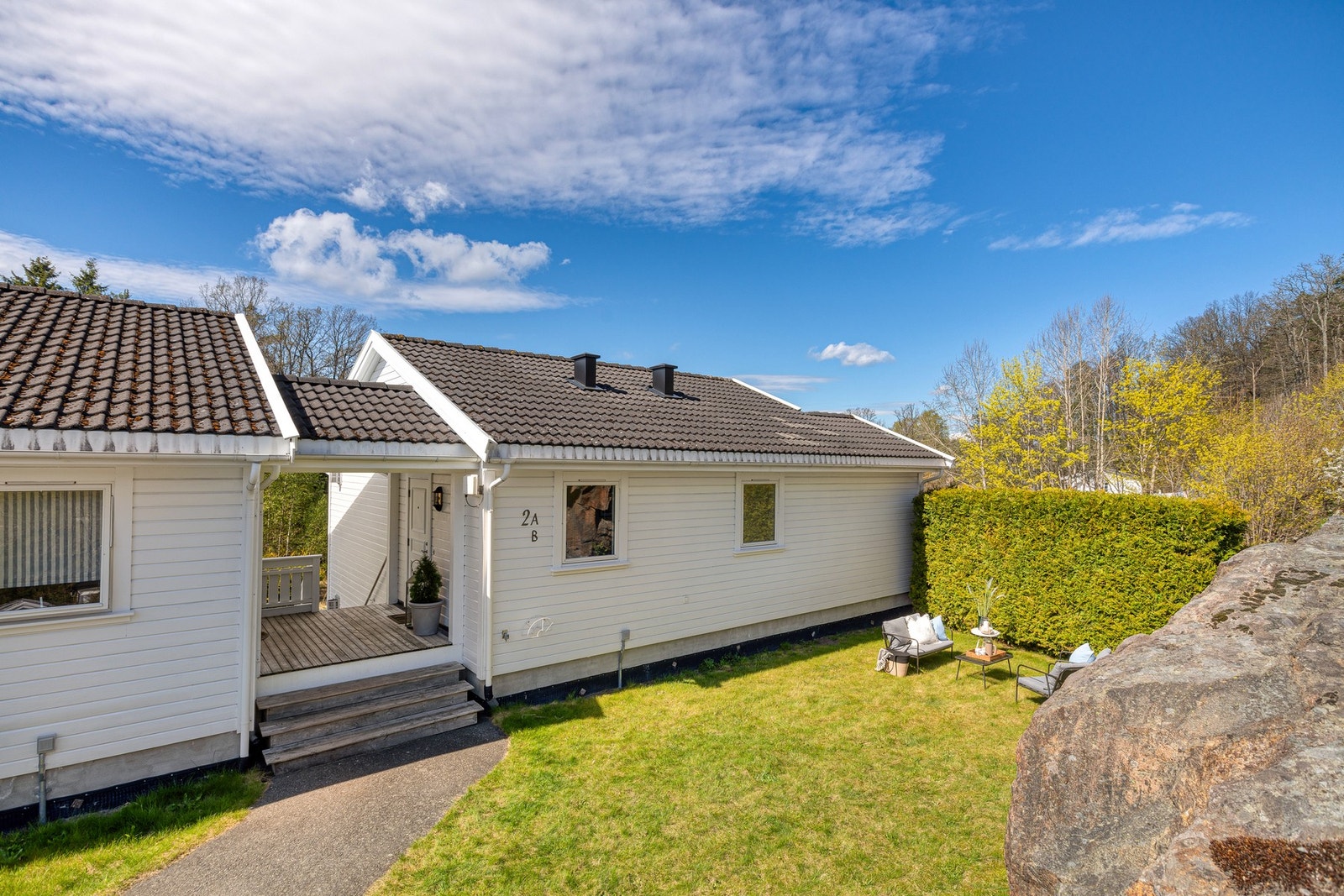 Ved inngangspartiet er det en stor, solrik hage som disponeres av denne leiligheten. Pipehetter skiftet 2025 Galleribilde