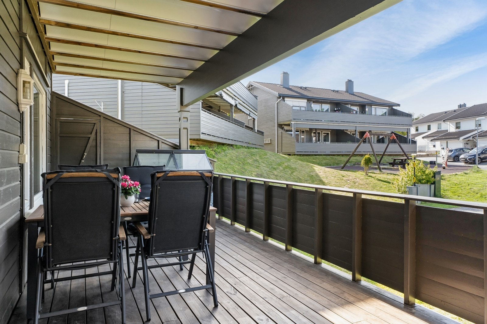 Fra terrassen er det utsyn mot borettslagets fellesarealer og lekeplass. Galleribilde