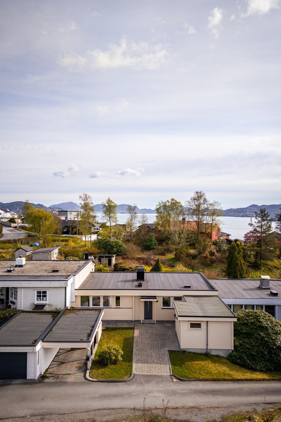 Eiendommen har en sentral plassering i rekken, med carport og adkomst fra veien. Galleribilde