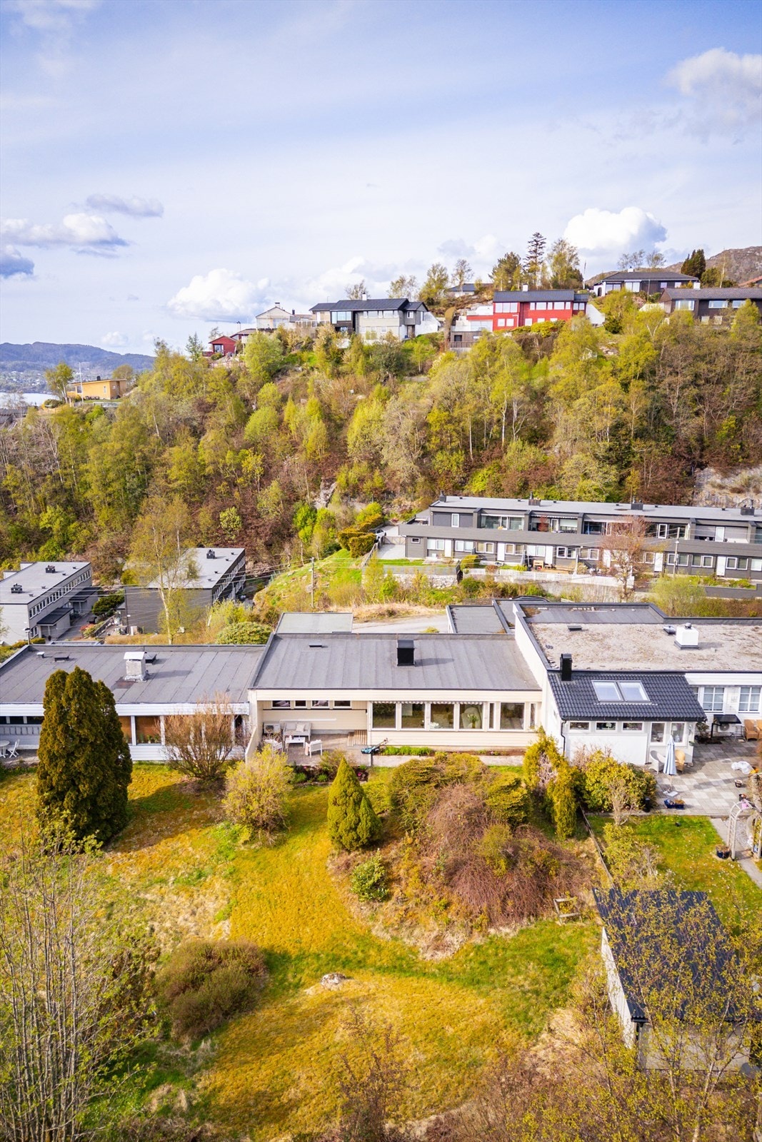 Boligen ligger fint til i terrenget med grønne omgivelser. Galleribilde