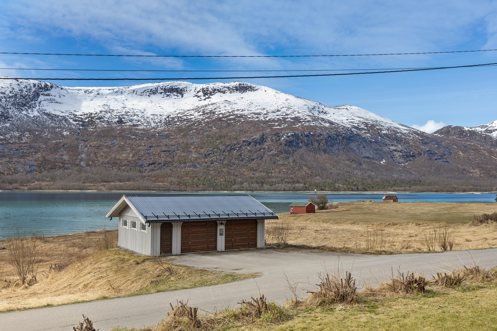 På nedsiden av veien står en praktisk dobbeltgarasje som medfølger eiendommen. Det er i tillegg god plass til parkering i innkjørselen. Galleribilde