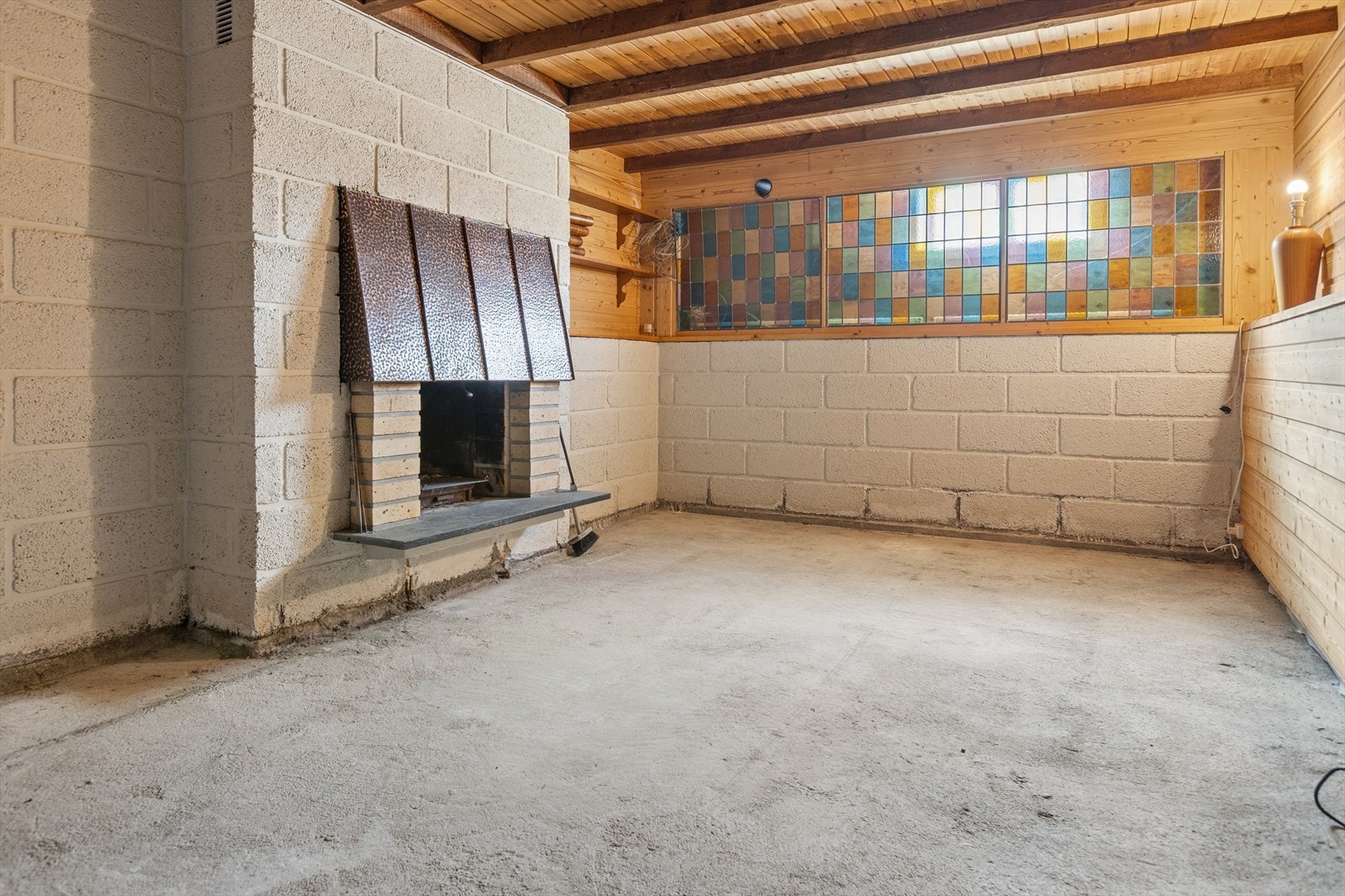 Romslig kjellerstue med egen peis og mosaikkvindu. Galleribilde