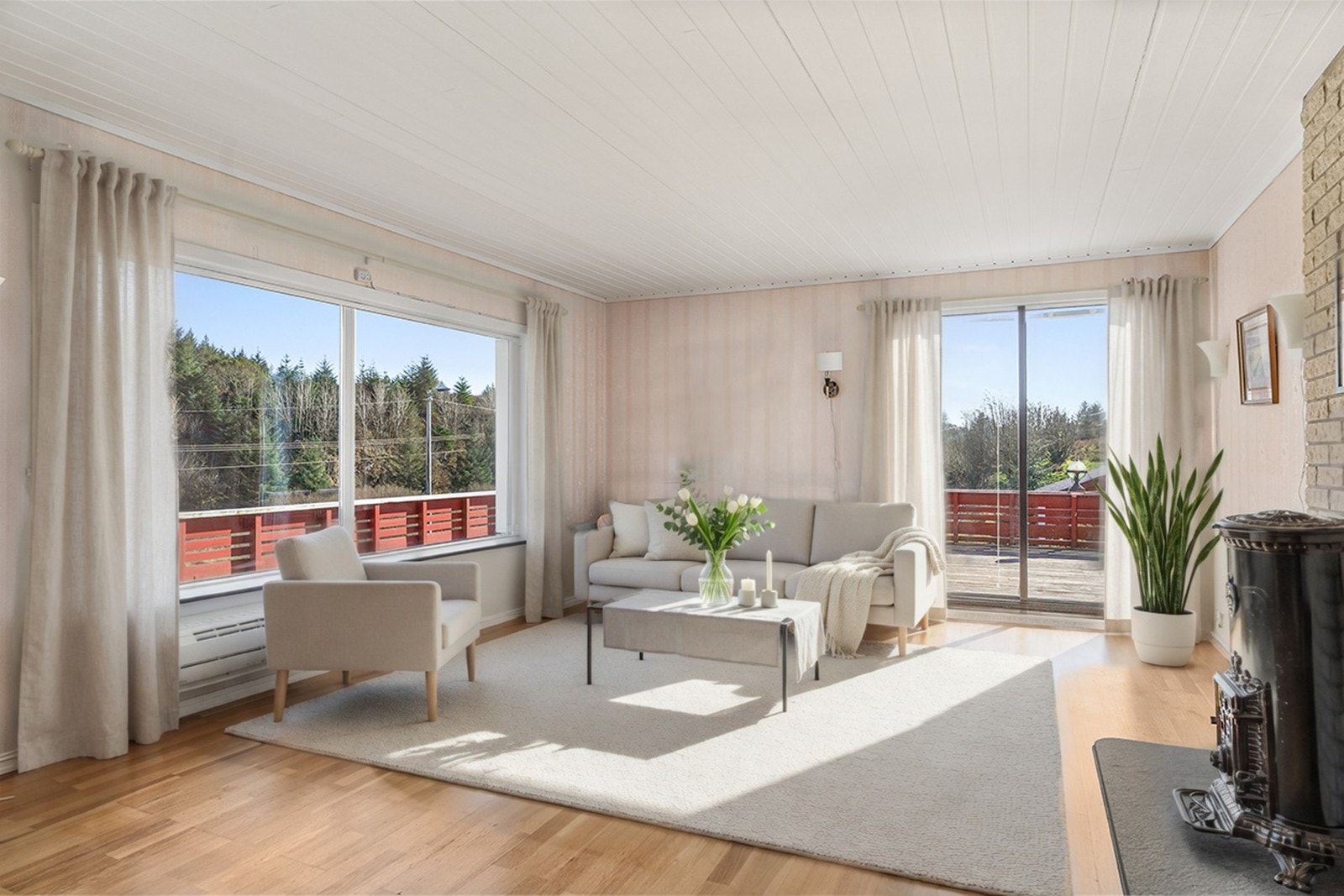 Eneboligen har en lys og fin stue med store vinduer og skyvedør ut til terrasse Galleribilde