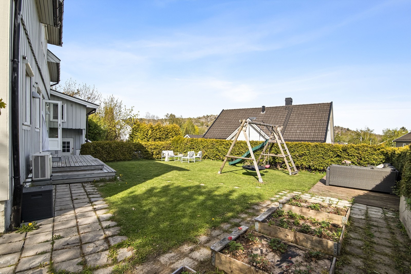 Tomten er opparbeidet med plen, belegningsstein og diverse beplantning. Galleribilde