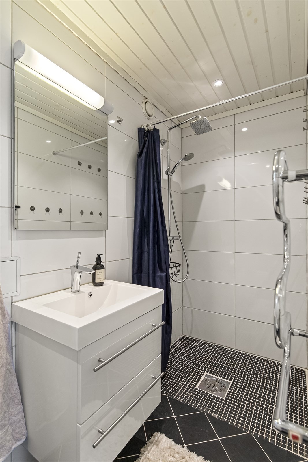 Badet i første etasje har flislagt gulv med gulvvarme og innfelte downlights i taket. Galleribilde