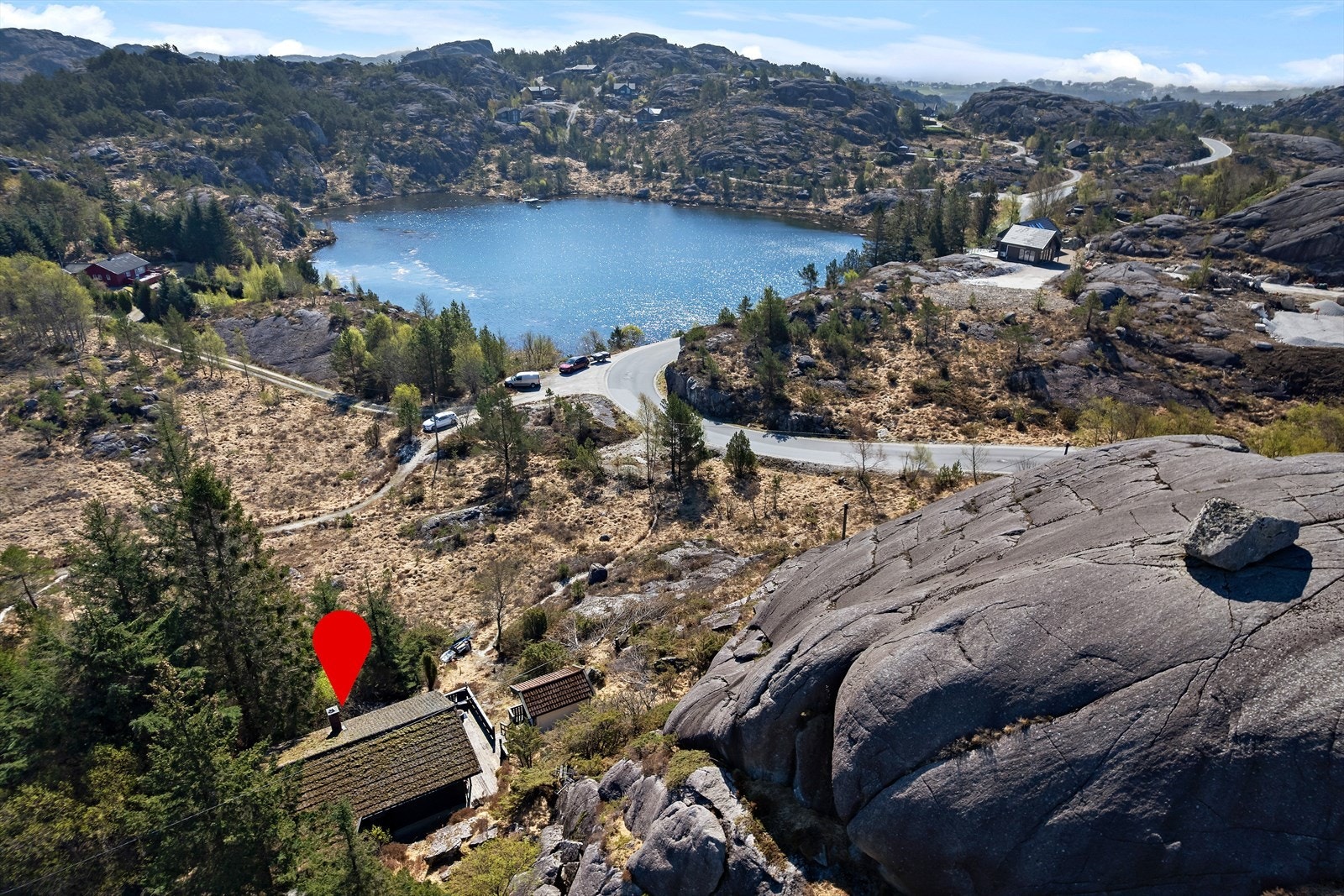 Hytta ligger fint til i terrenget med utsikt mot badevann. Galleribilde