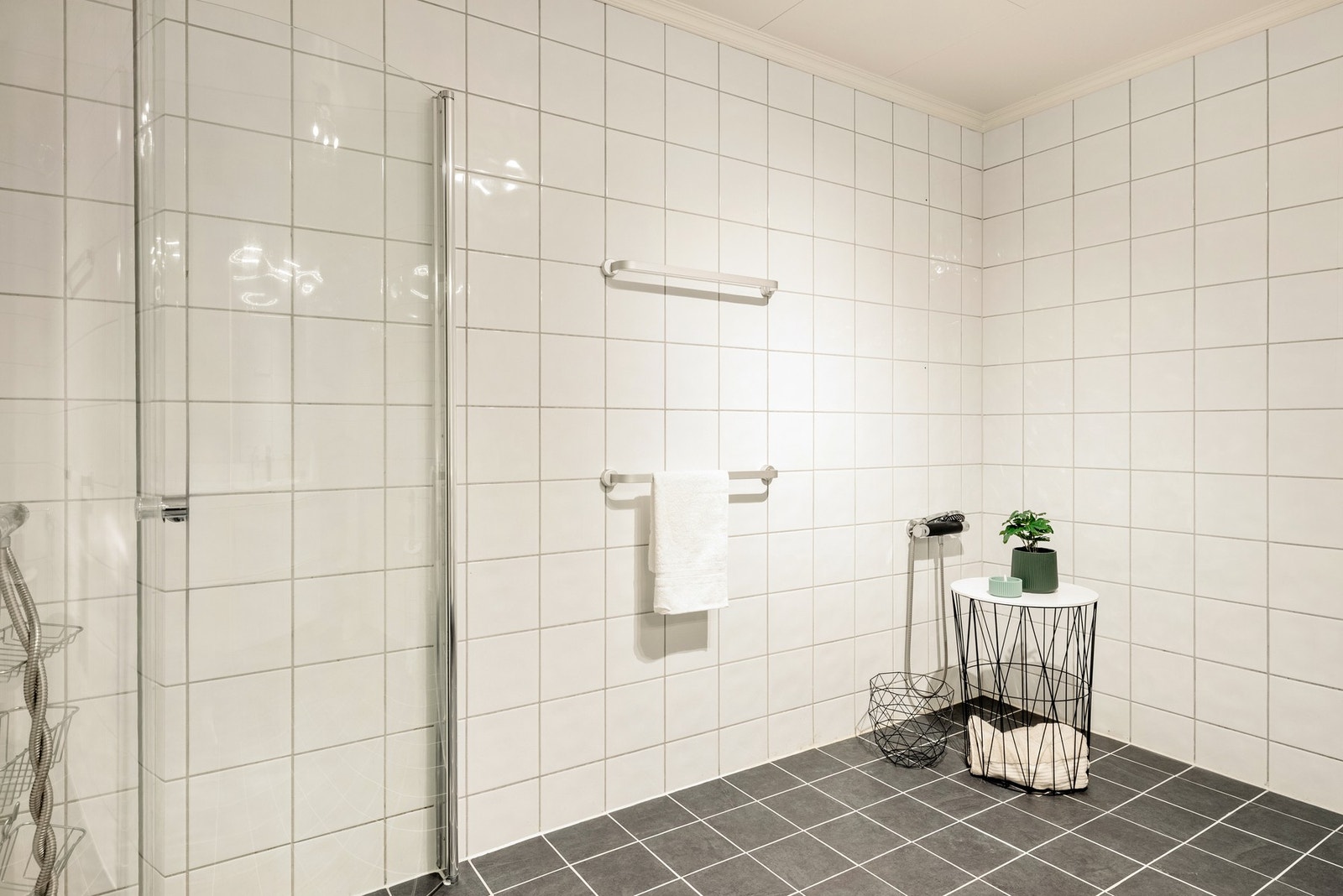 Badet er innredet med toalett, dusjhjørne, og baderomsmøblement med speil og belysning. Galleribilde