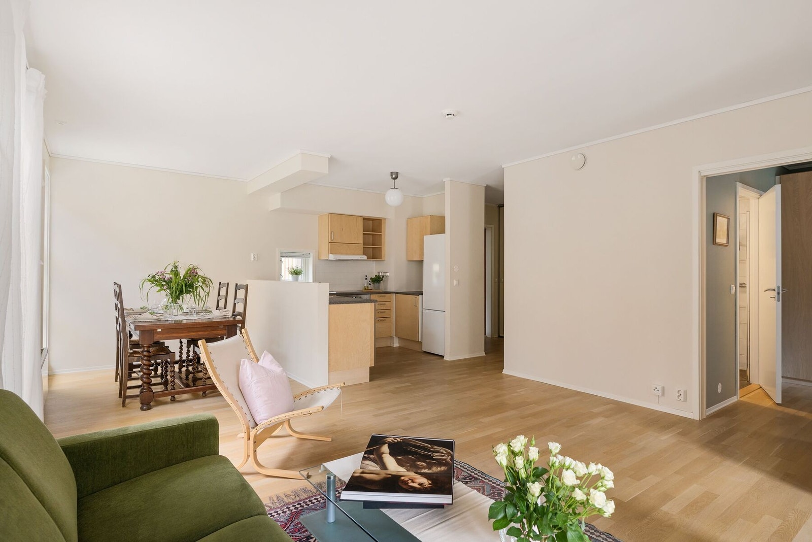 Romslig oppholdsrom på 30,3 m² delt inn i flere soner med stue, spisestue og kjøkken. Galleribilde