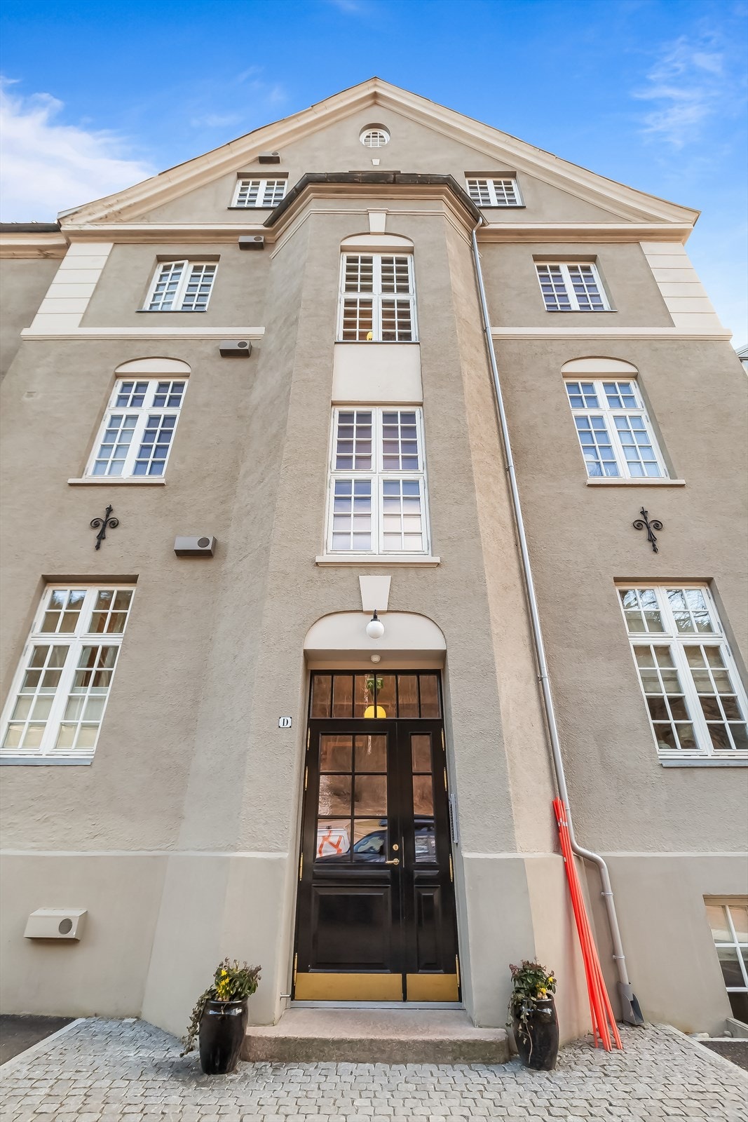 Byggets historiske karakter fra 1925 er bevart, med en fasade i pusset og malt murverk. Dette er byggets hovedinngang. Galleribilde
