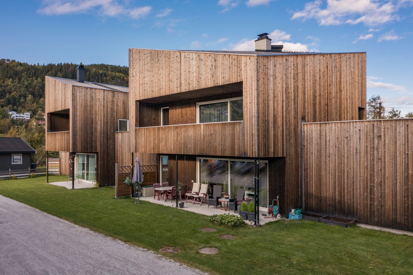 Gressplen rundt byggene og diverse beplantninger og trær rundt om på tomten. Galleribilde