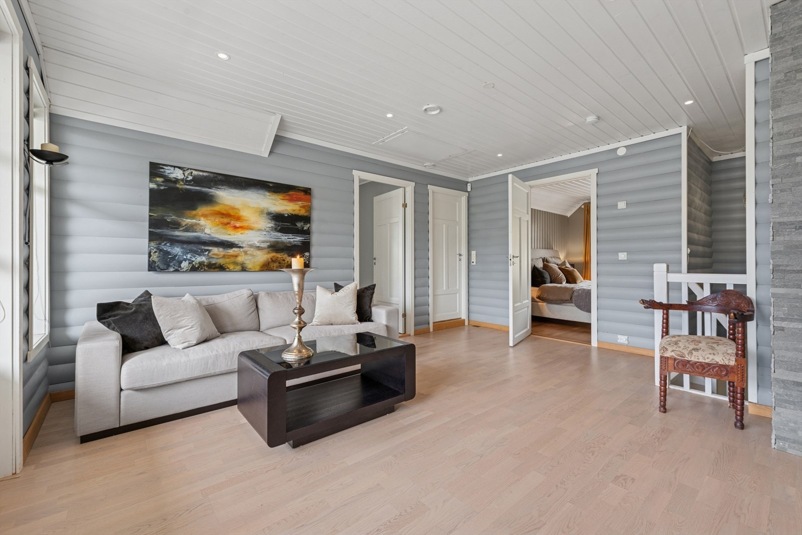 Rommet har god plass til en sofagruppe og gir tilgang til etasjens soverom. Galleribilde