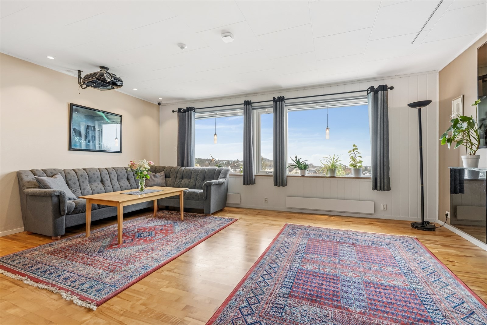 Stuen i andre etasje er lys og romslig, med store vindusflater som gir rikelig med naturlig lys og rammer inn den flotte utsikten på en elegant måte. Galleribilde