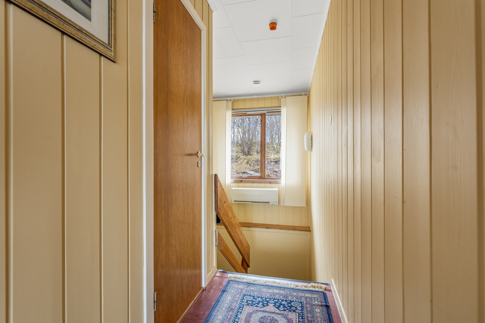 Tretrappen er et funksjonelt bindeledd mellom boligens to etasjer. Den solide konstruksjonen gir en trygg og komfortabel forbindelse mellom etasjene, samtidig som trappen fungerer som et naturlig element i planløsningen. Galleribilde