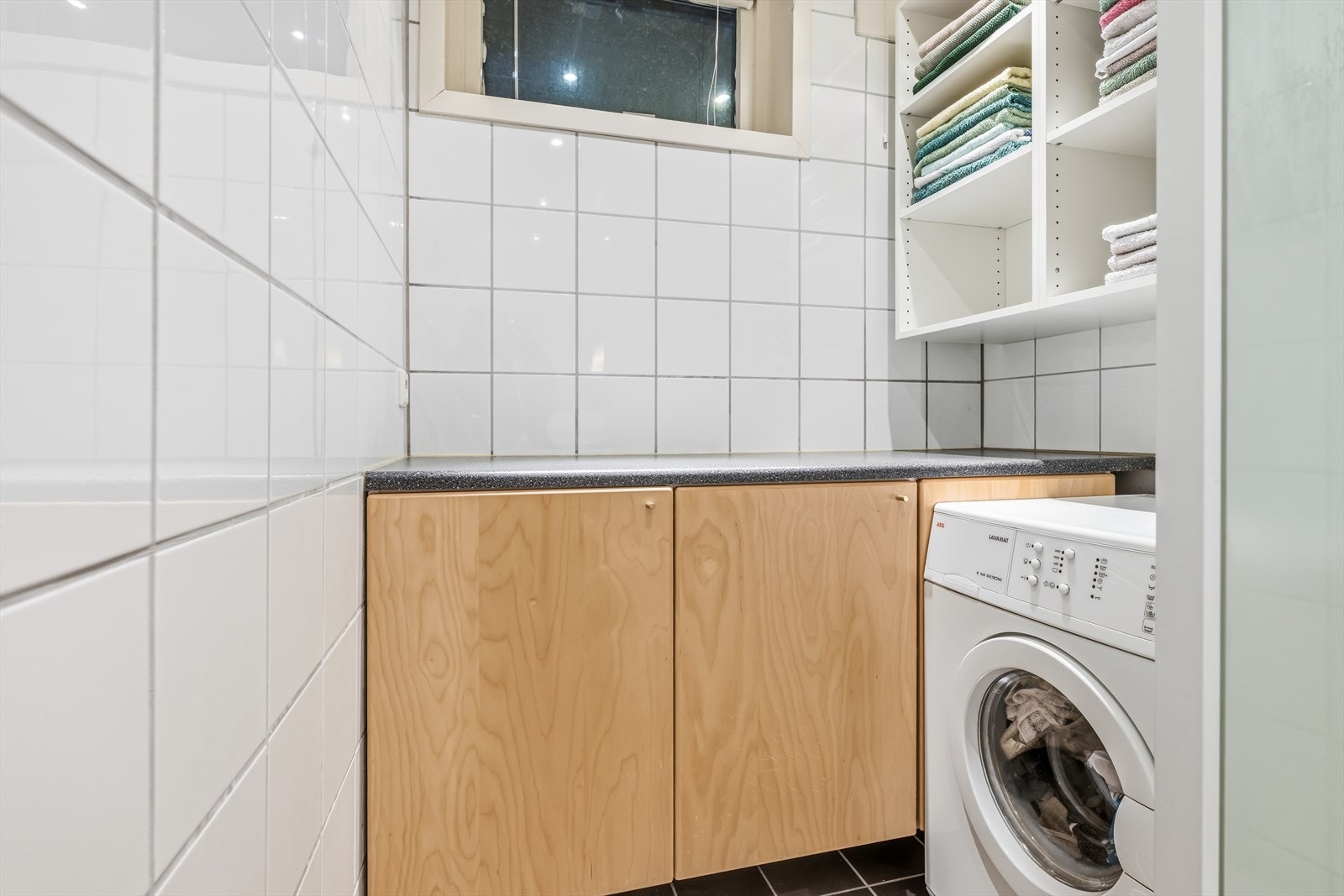 I tilknytning til badet er det en praktisk nisje med opplegg for vaskemaskin og ekstra benkeplass. Galleribilde