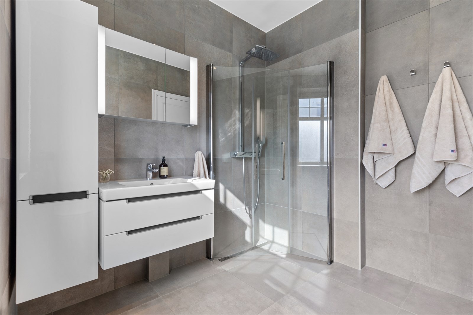 Baderomsinnredning, toalett, blandebatteri/kran og fliser er fra Villeroy & Boch og regnfallsdusjen er fra HansGrohe. De ter varme i veggen for tørking av håndklær Galleribilde