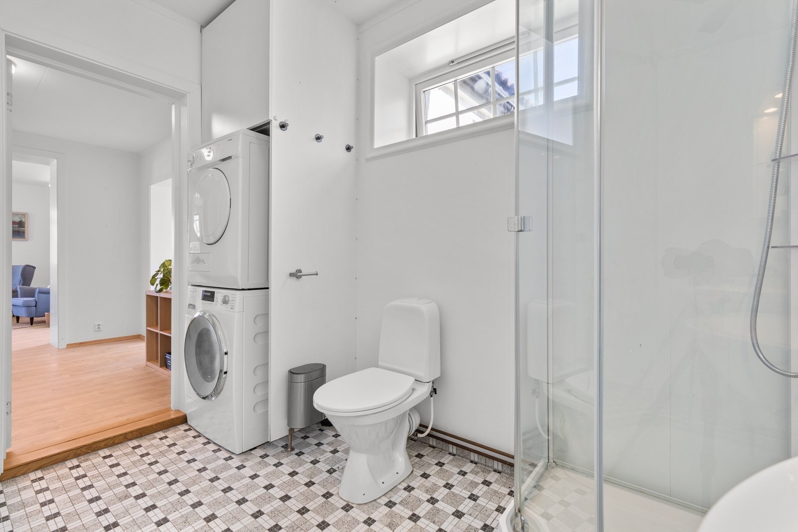 Badet har vindu og plass og opplegg for vaskemaskin og tørketrommel. Galleribilde