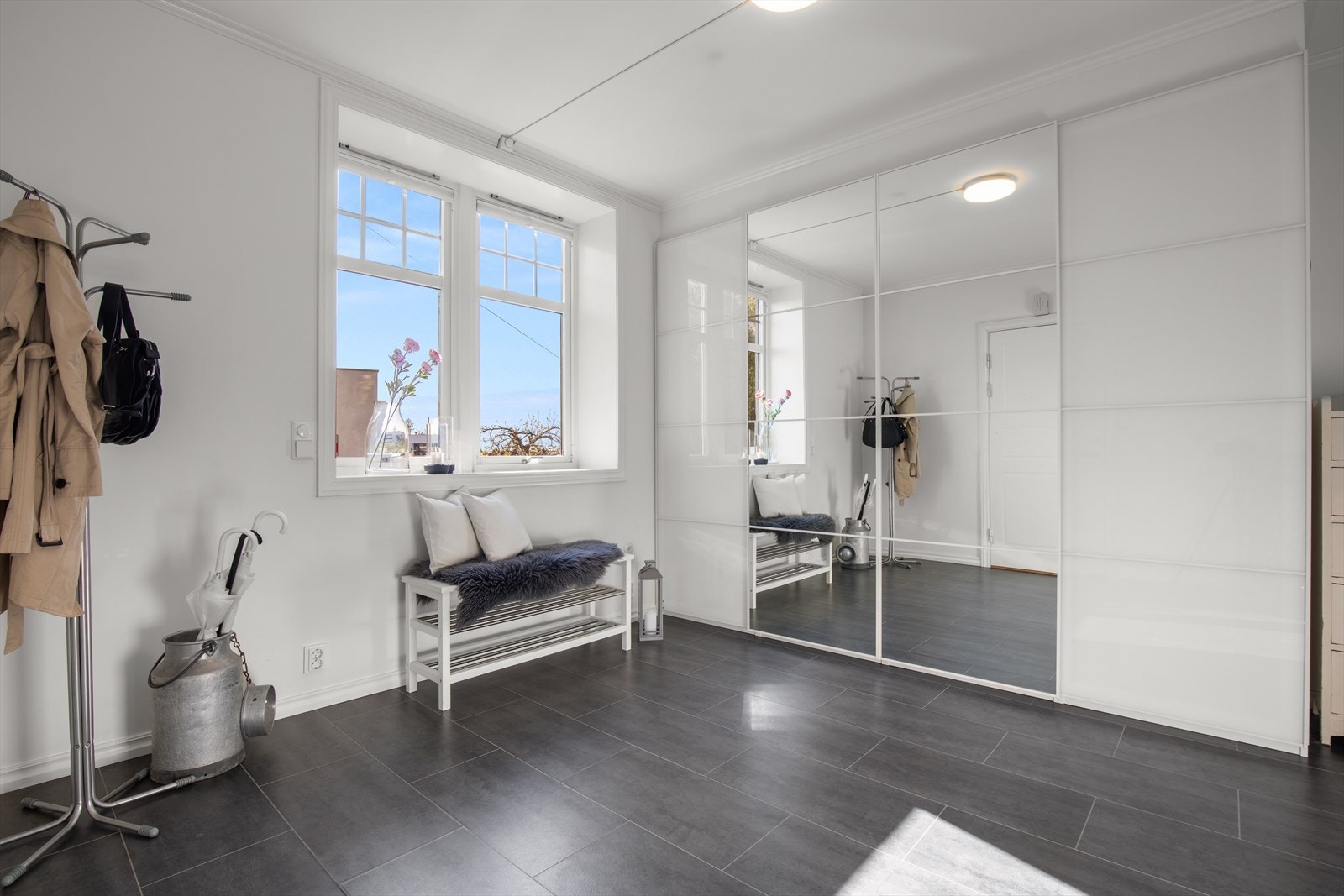 Et stort krysspostvindu i jugenstil fyller hallén med lys. Det er varme i gulvet. Galleribilde