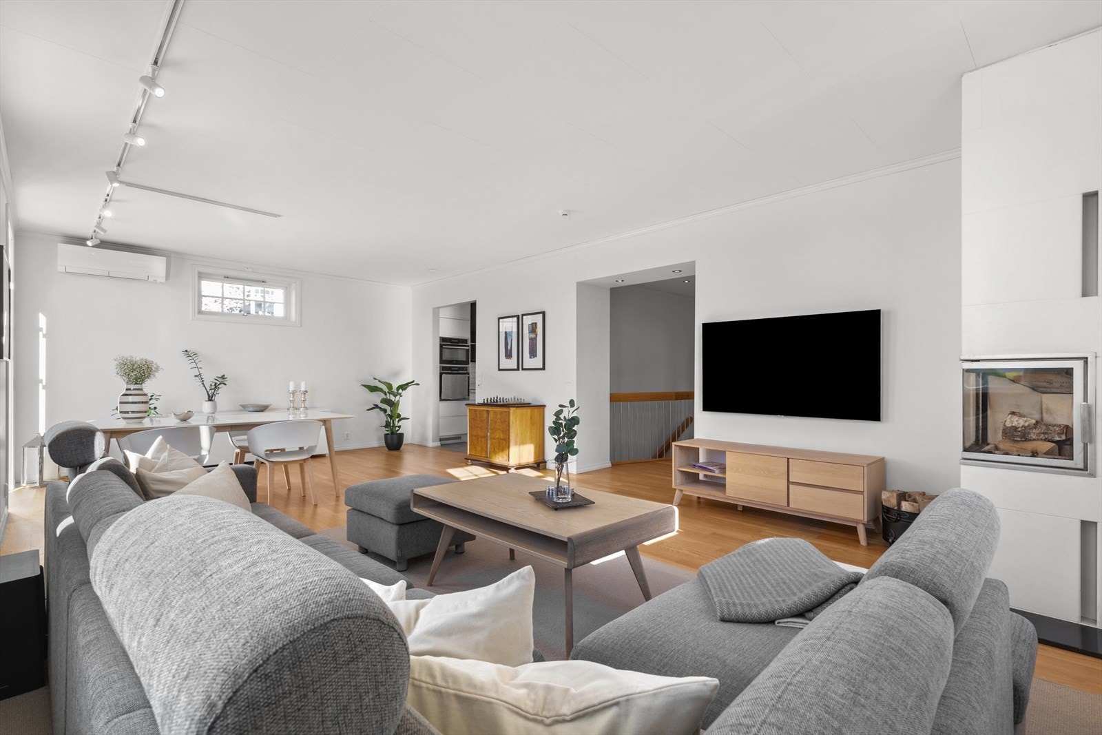 Det er god plass til et stort spisebord hvor familie og gjester kan samles og nyte både måltider og utsikten i en ende og stor sofagruppe rundt en moderne peis med glass, installert i 2013, på motsatt side. Galleribilde