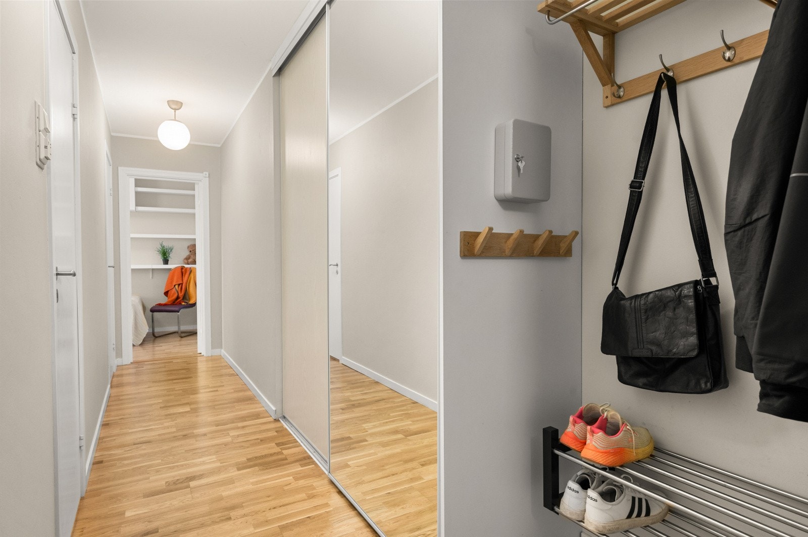 Lys og innbydende gang med romslig skyvedørsgarderobe med speildør. Galleribilde