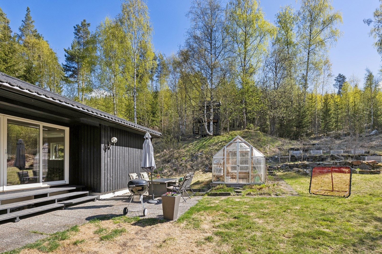Den sør-østvendte terrassen på 9 m² har utgang fra stuen og gir en fin overgang til hagen. Galleribilde