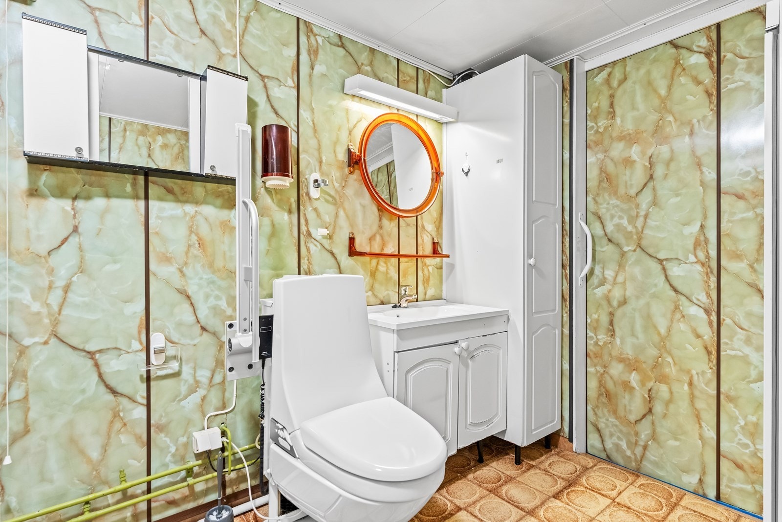 Rommet har en eldre innredning bestående av skap med profilerte fronter, servant, klosett, dusjkabinett og opplegg for vaskemaskin. Det bør påregnes renovering. Galleribilde