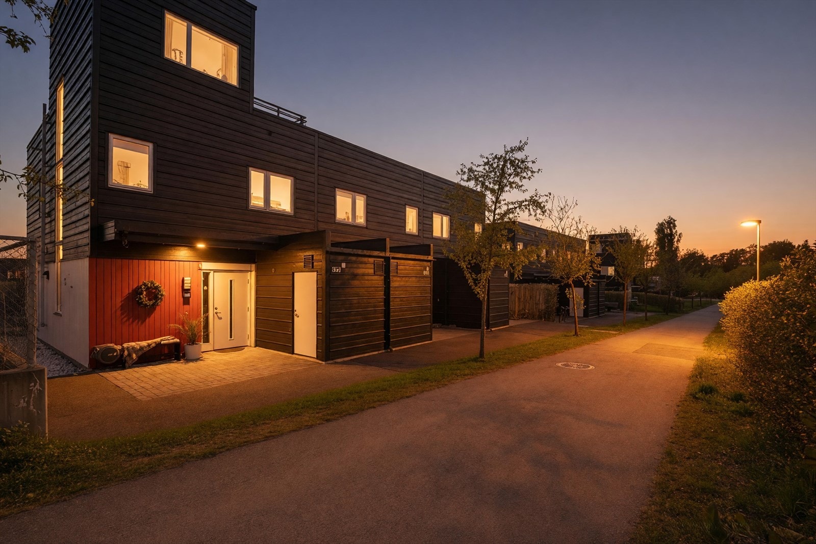 Tomten er pent opparbeidet med asfalt, gress og diverse beplantning. Galleribilde