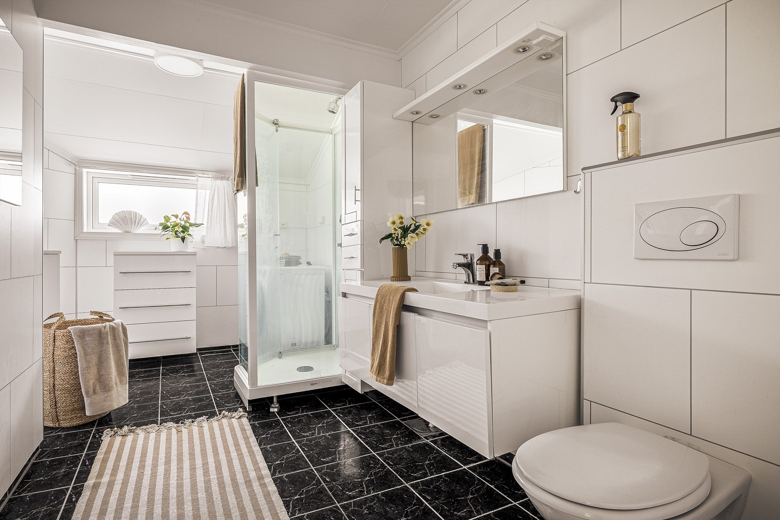 Badet i hovedetasjen har keramiske gulvfliser, veggmontert toalett og dusjkabinett. Galleribilde