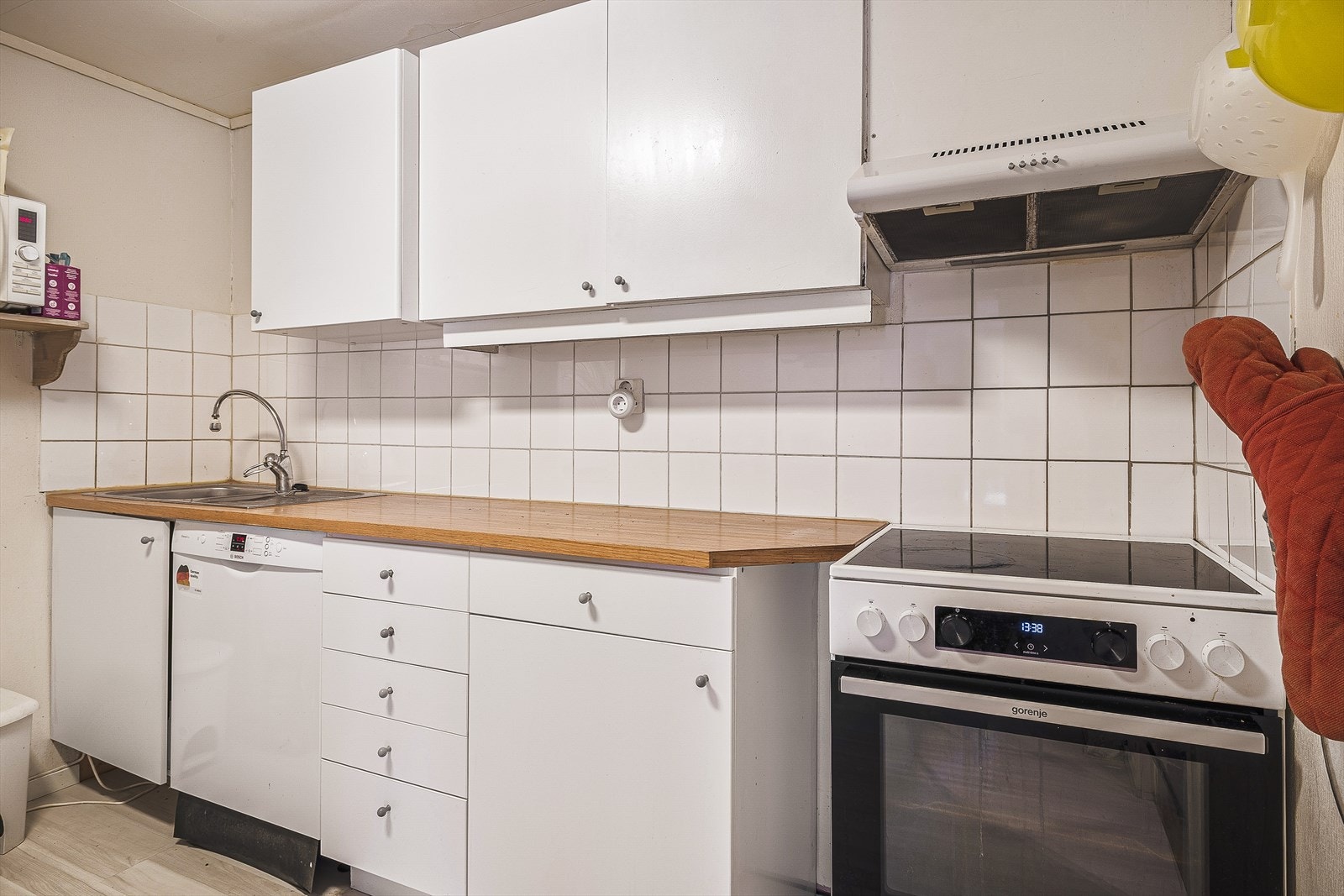 Kjøkken i underetasjen med glatte fronter, utstyrt med stekeovn og platetopp. Galleribilde