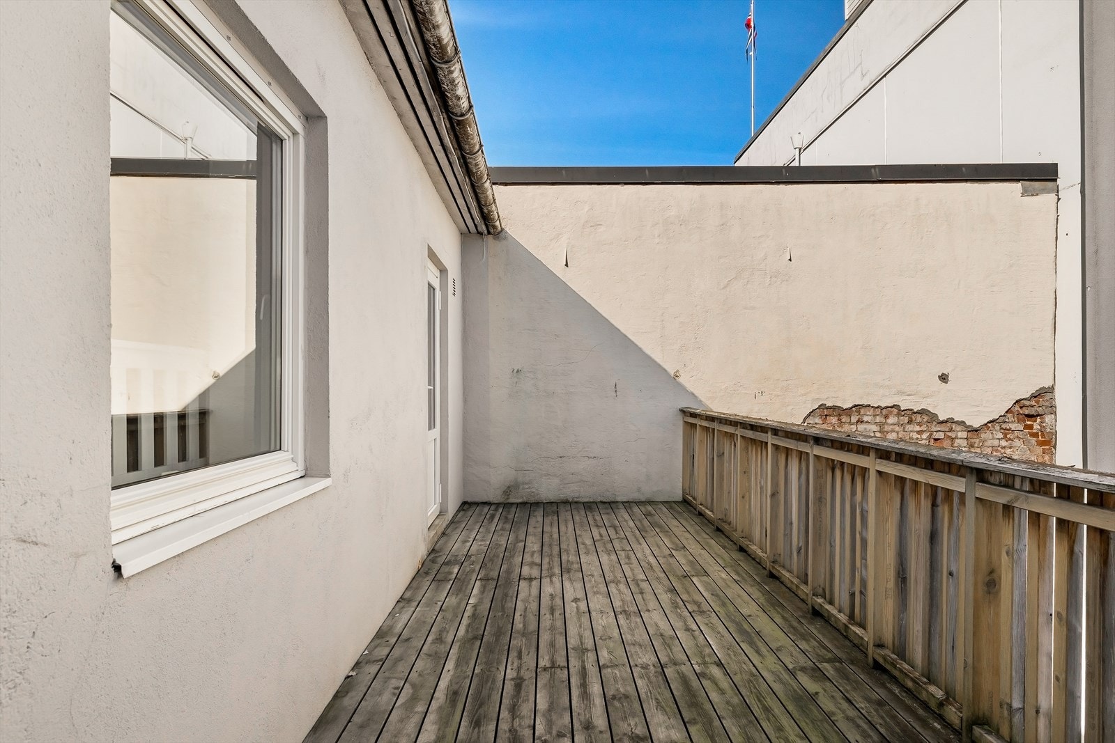 Balkongen er bygget i impregnerte materialer og har rekkverk og levegg i tre. Galleribilde