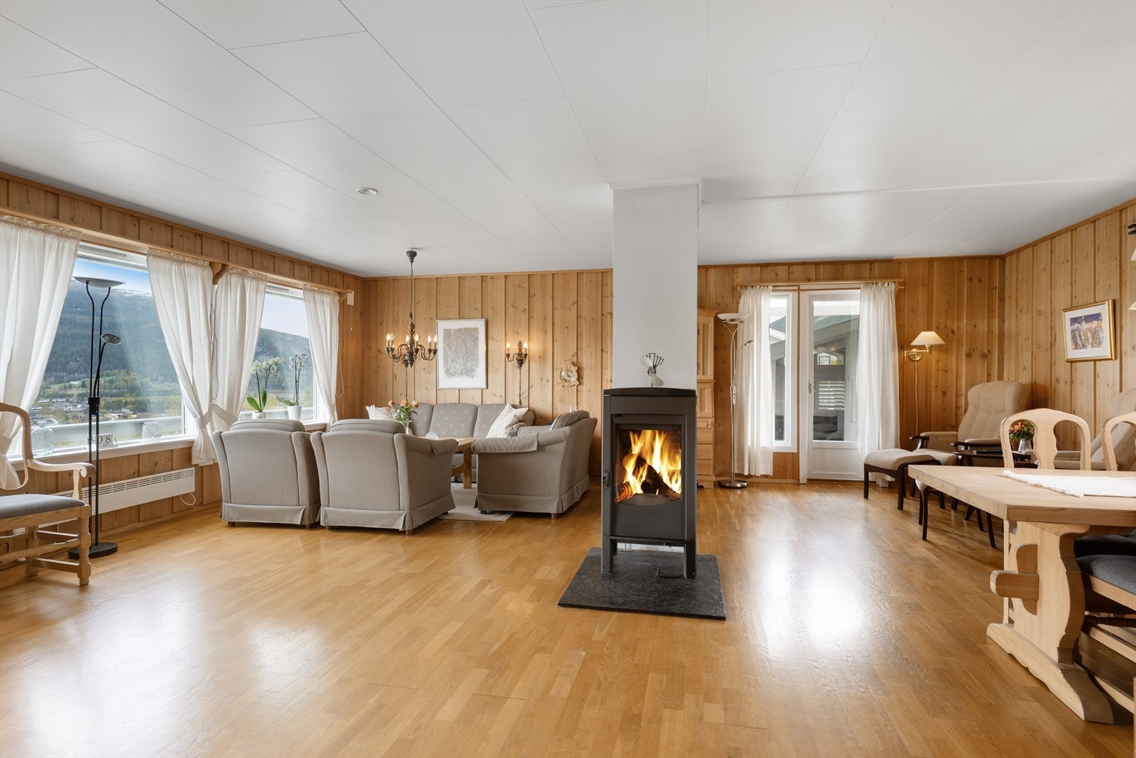 Stua er romslig m/god plass til både sofagruppe, lenestoler og spisebord. Peisovnen gir en lun atmosfære. Galleribilde