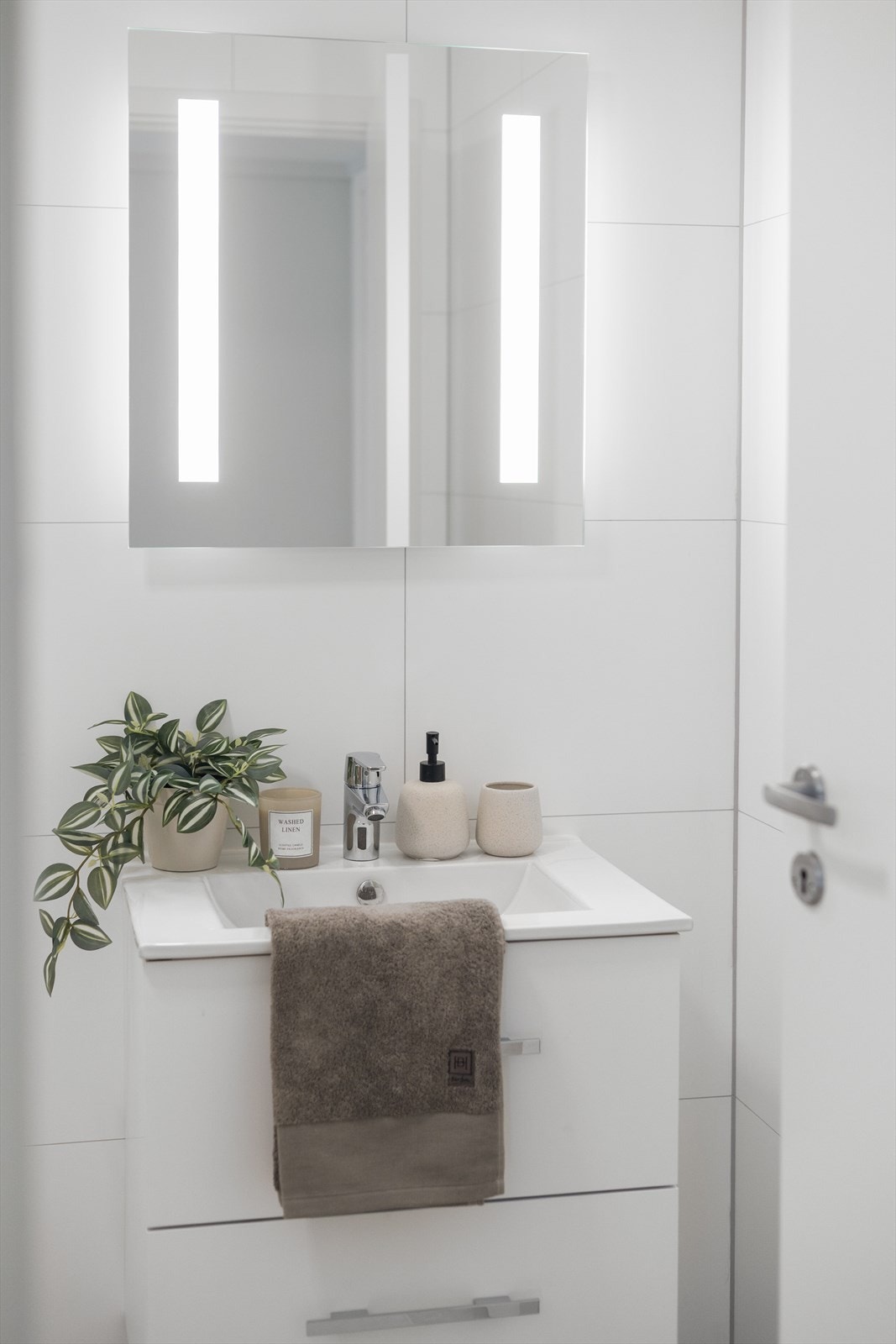 Badet er utstyrt med servant, speilskap med belysning, toalett og dusjhjørne. Galleribilde