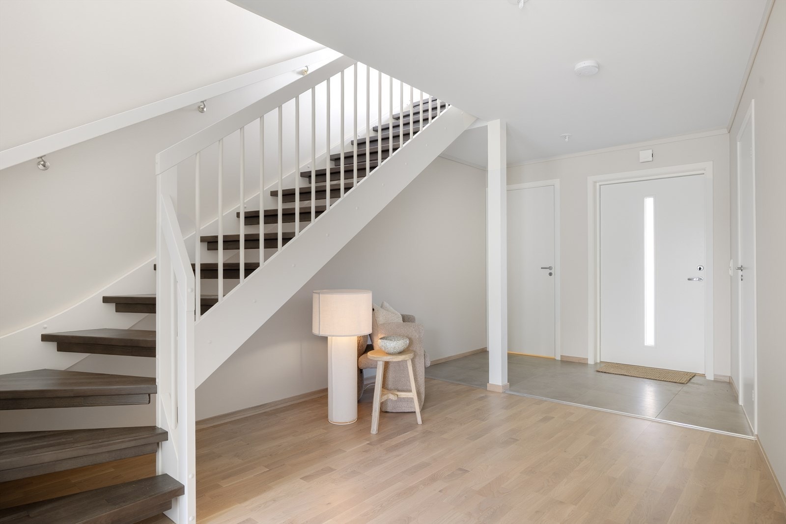 Romslig hall med trapp opp til hovedetasjen. Gjennomgående eikeparkett gir et helhetlig inntrykk. Galleribilde