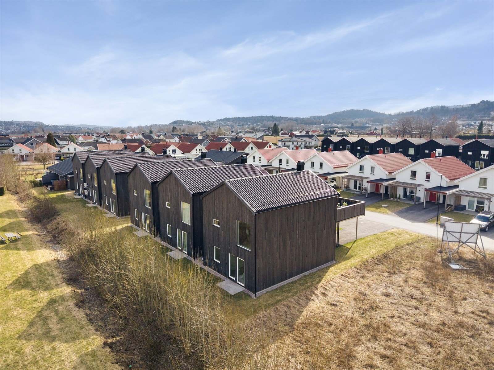 Moderne arkitektur med mørk trekledning og funksjonelle linjer. Galleribilde